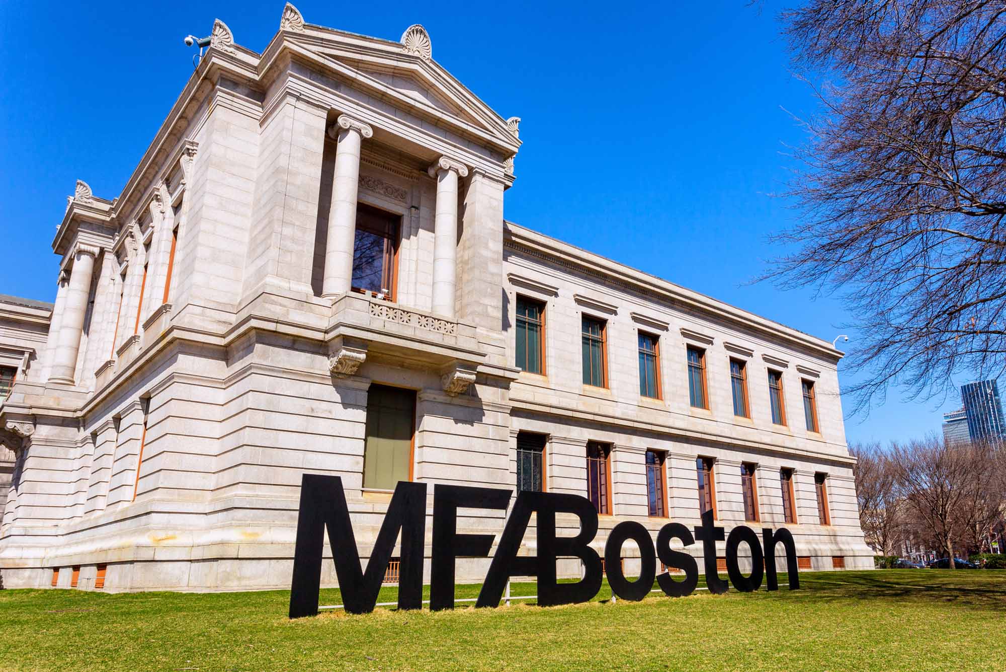 Photo: A picture of the exterior of the Museum of Fine Arts in Boston. In front of the building is a sign on the lawn that says "MFA Boston"