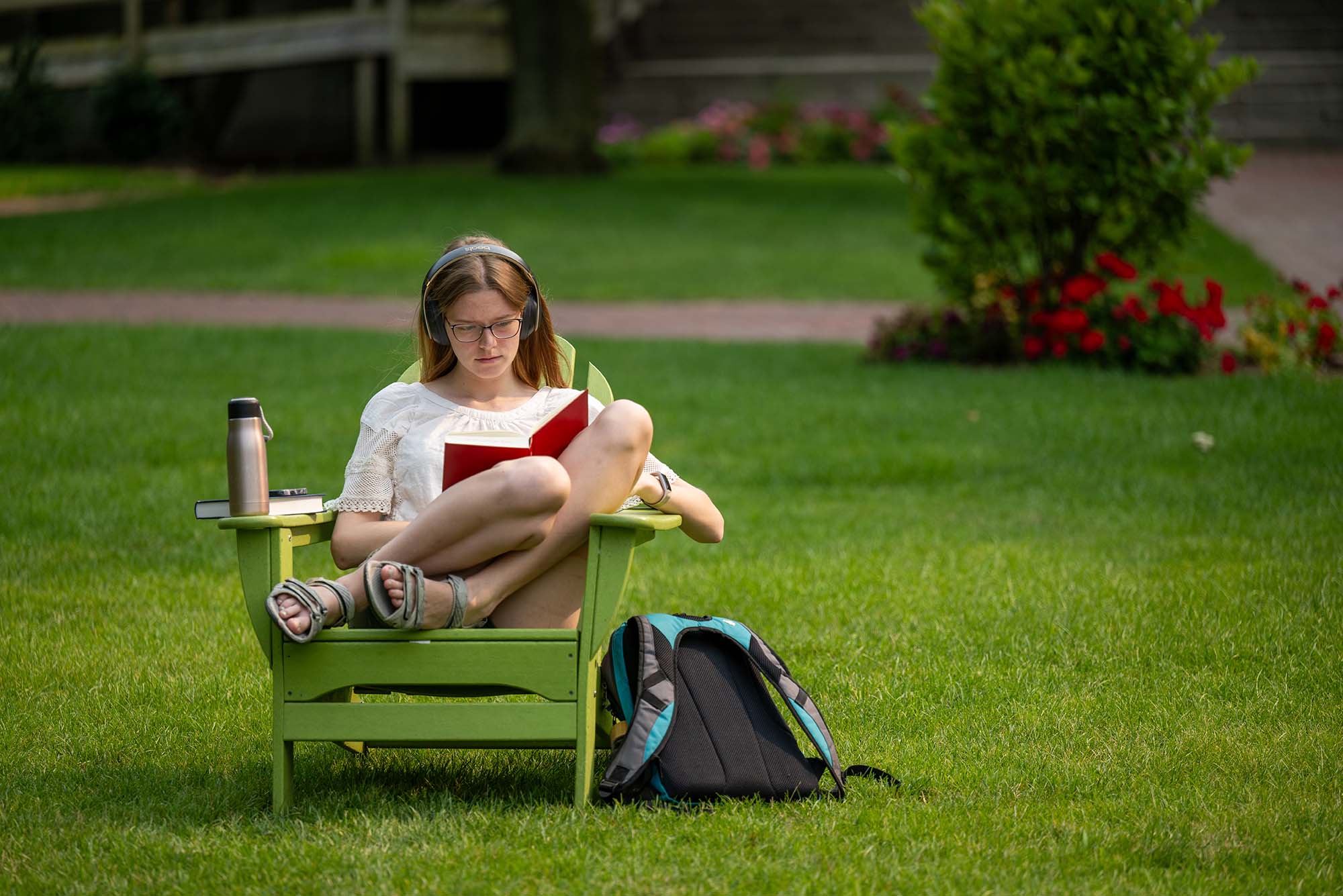 Photo: A picture of a student sitting in a lawn chair outside and reading a book