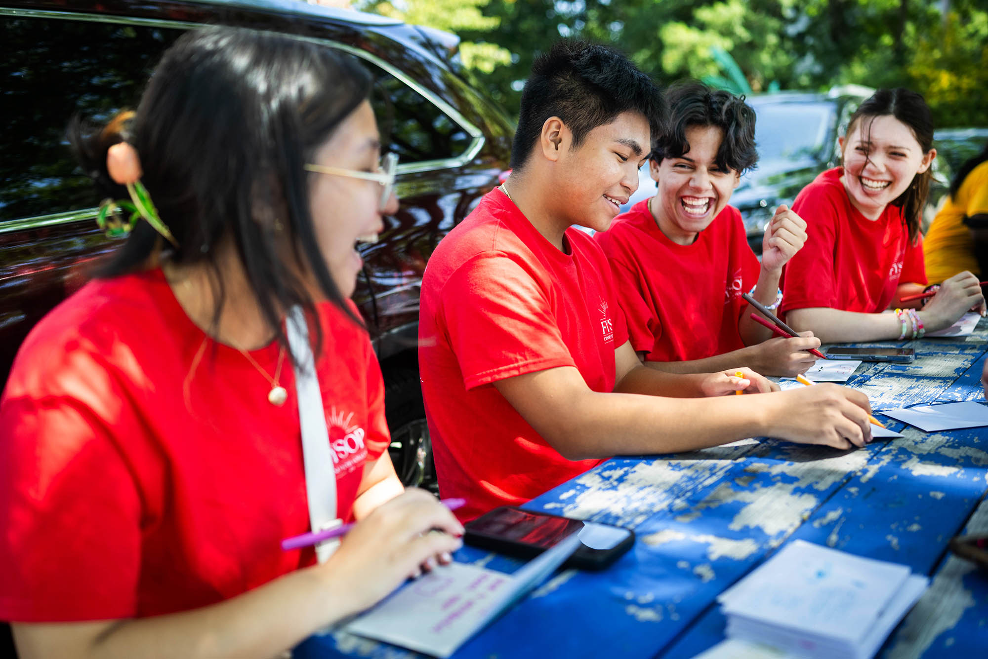 Photo: New BU freshmen (Left to right) Saku Cui (CAS 28), Kurt Lang (ENG 28), Erick Cestelos (CFA 28) and Ilyena Metzger (CFA 28) share a laugh while writing inspirational notes to students