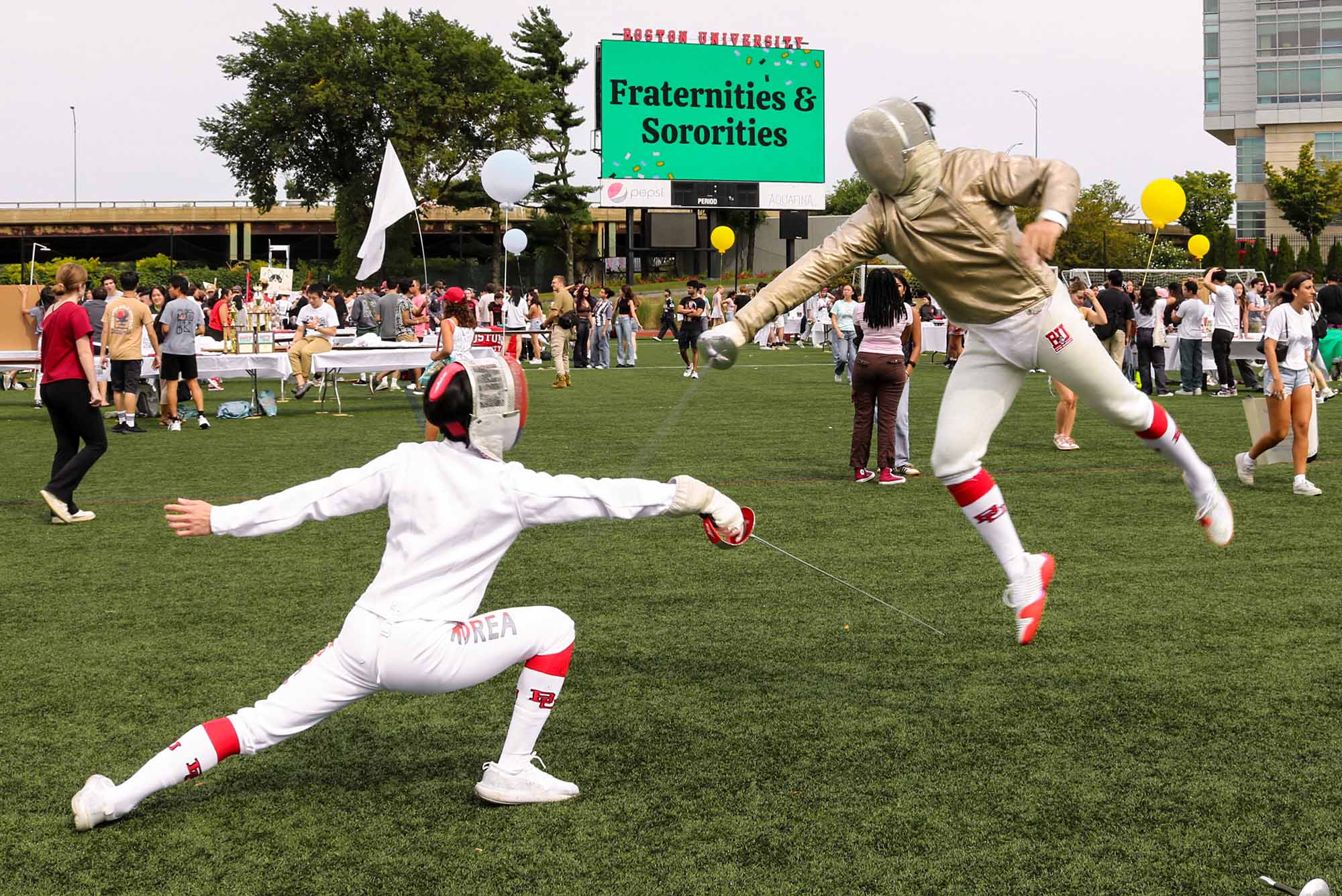 Photo: A picture of two fencers at SPLASH, Boston University's Student Activities Fair, sparring on an open field