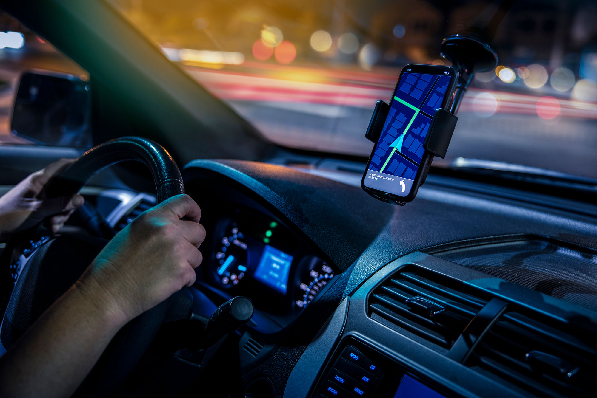Photo: A person driving a car using their phone as a GPS.