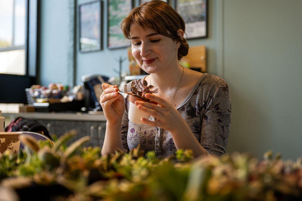 Photo: A student painting the pot of a succulent