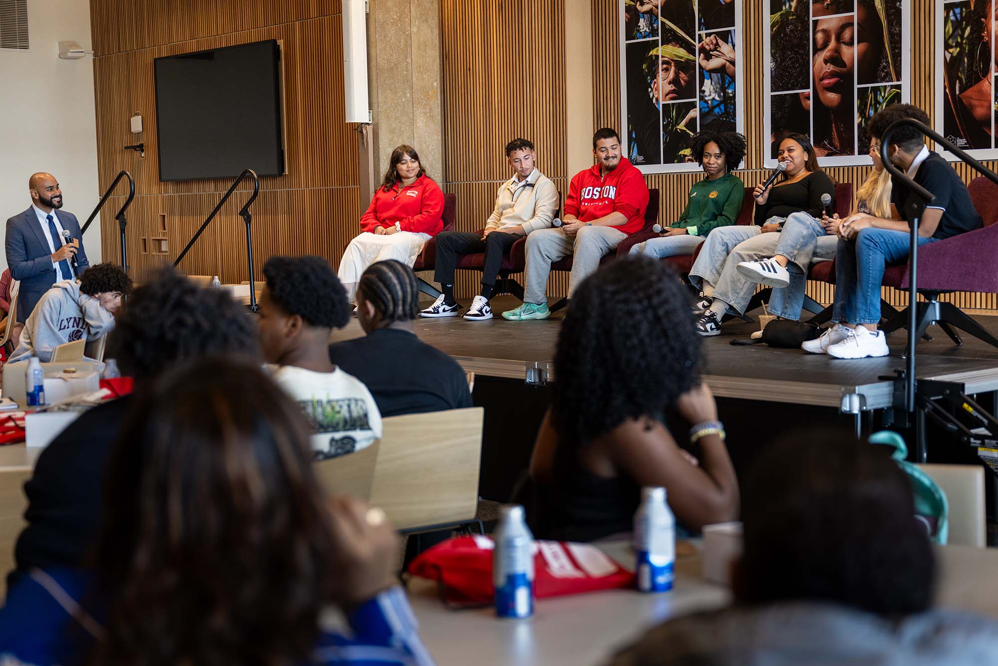 Photo: A panel of BU students sitting on a stage while people listen at tables in an audience