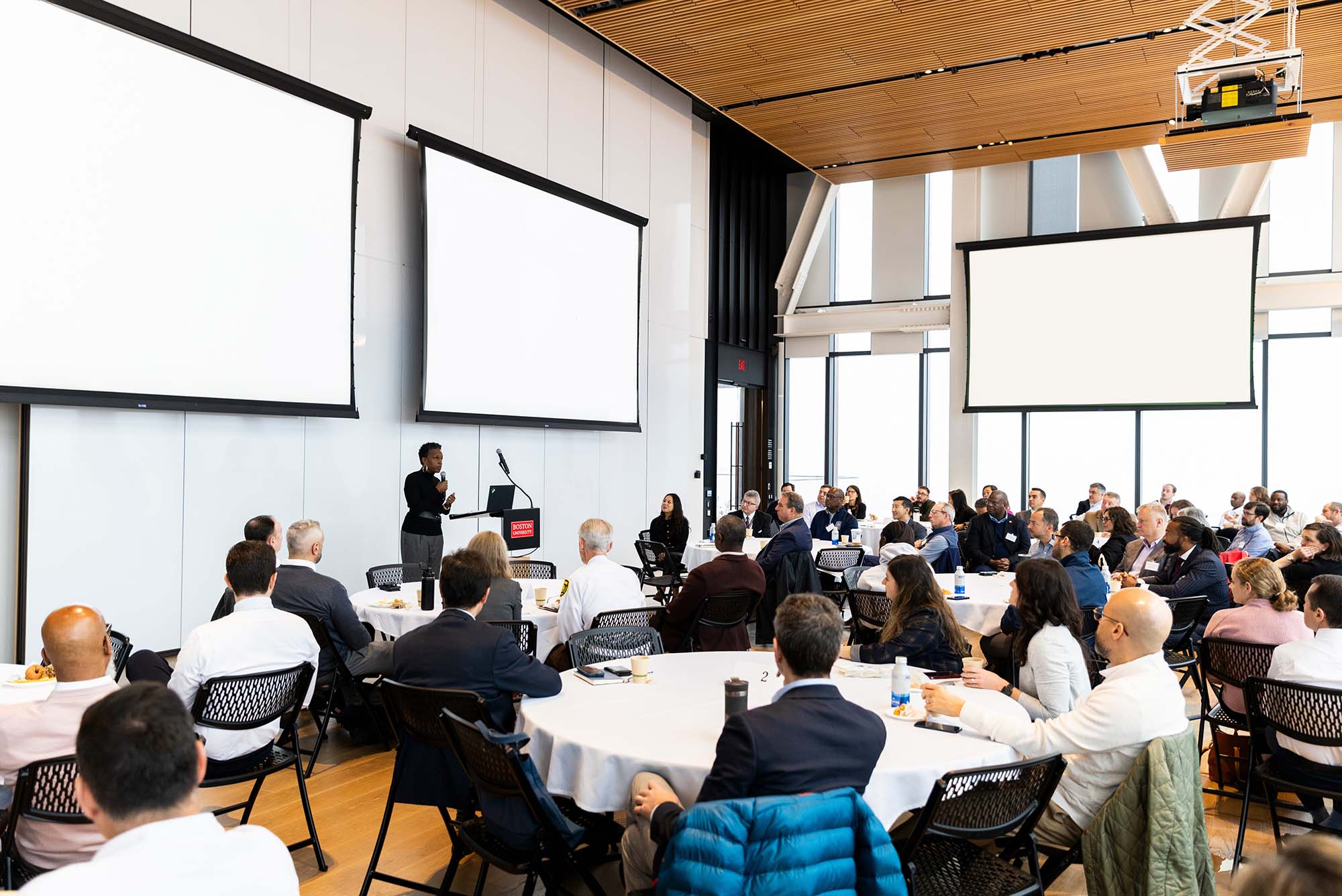 Photo: A crowd of people sit in a BU conference room to attend a presentation.