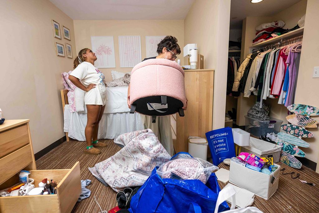 Photo: A female college student unpacking her room with her mom