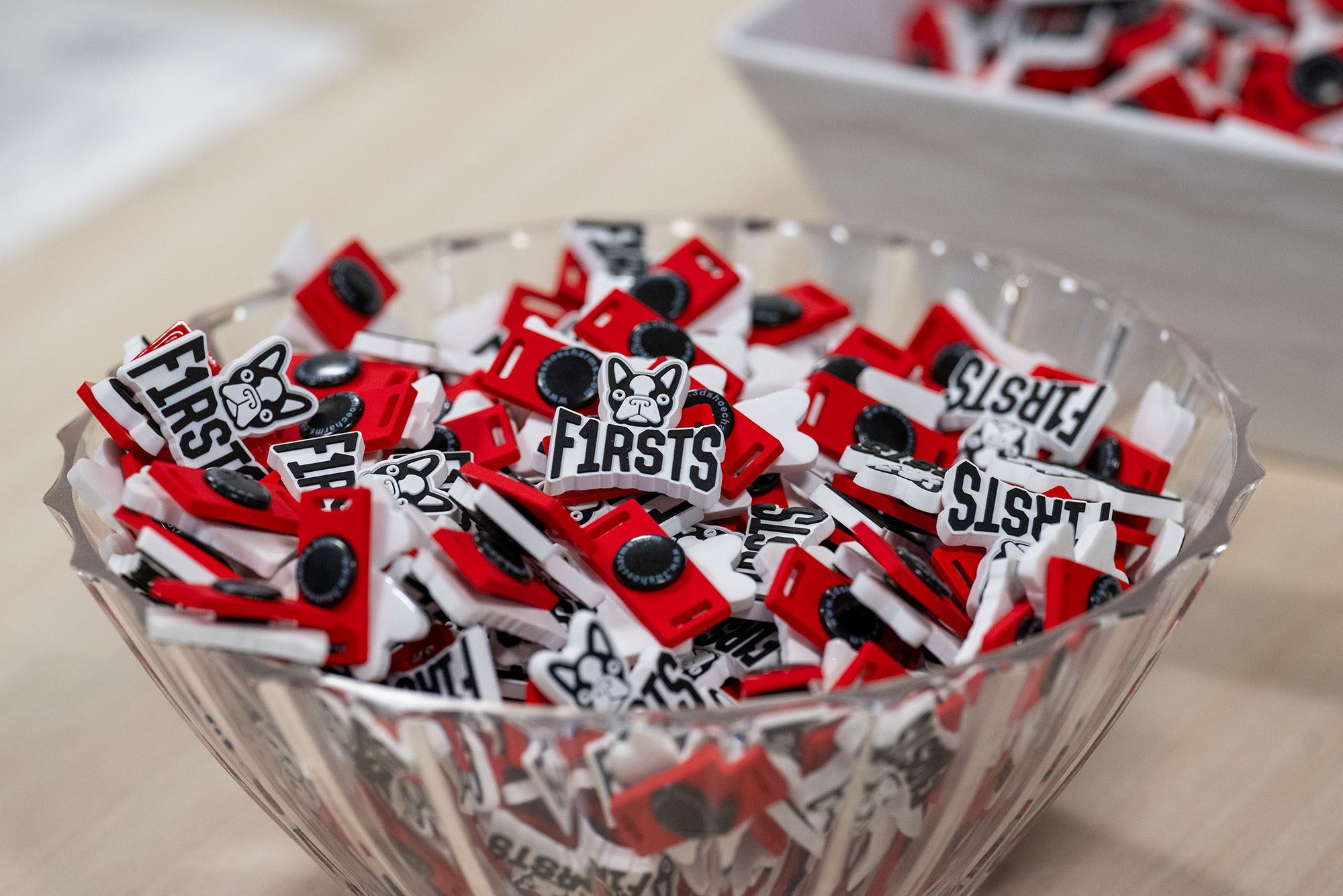 Photo: A bowl of Pins that say "Firsts" with a BU Boston Terrier logo