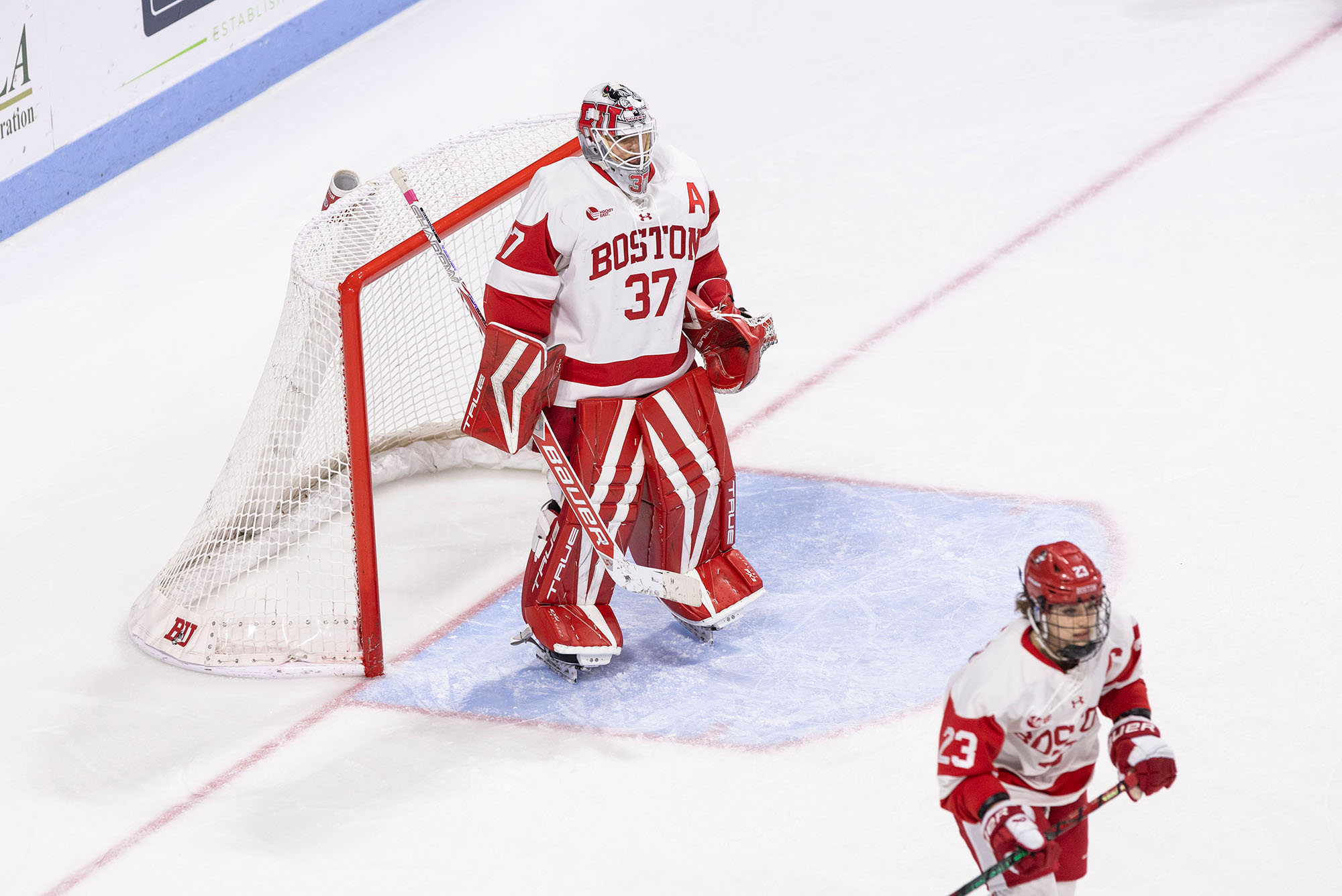 Photo: A female hockey goalie standing in front of the net wearing Boston University gear during a game