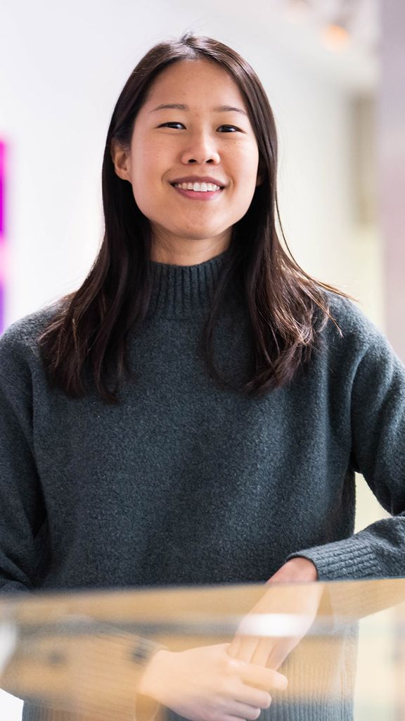 Photo: CAS professor Lynne Chantranupong, a young Asian woman wearing a grey sweater, poses for a photo