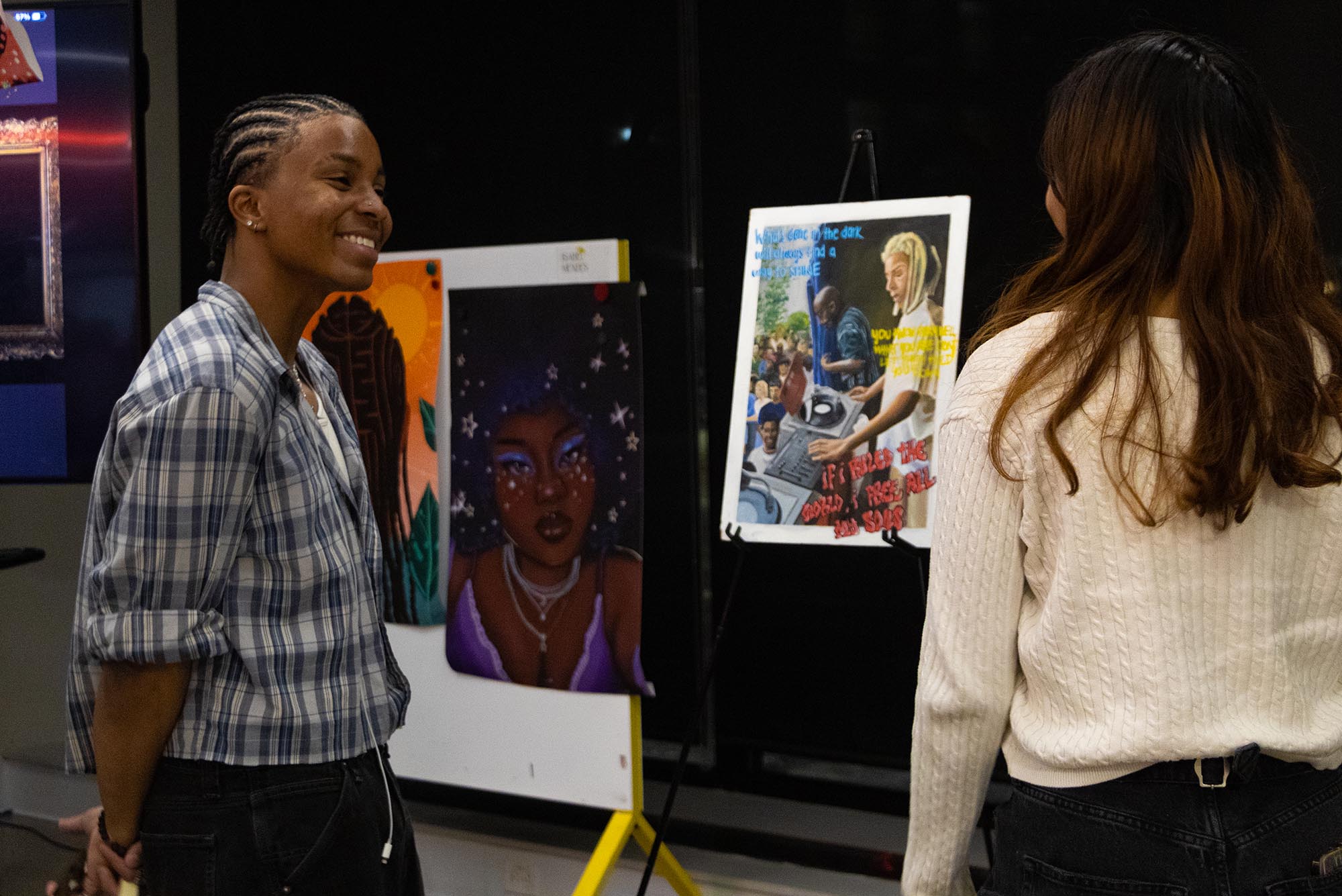 Photo: Two people conversing over an art exhibit