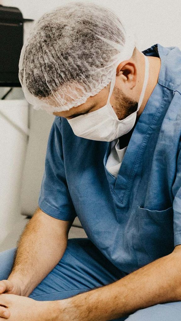 Photo: A doctor sitting with an air of sadness over them