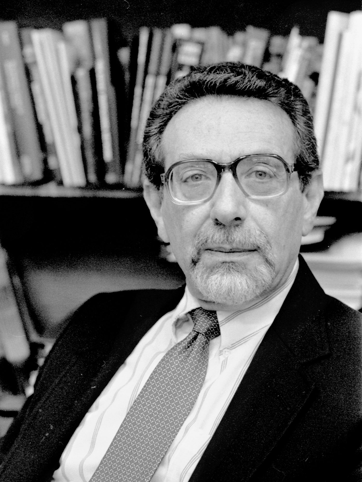 Photo: Black and white photo of a man wearing a suit and glasses
