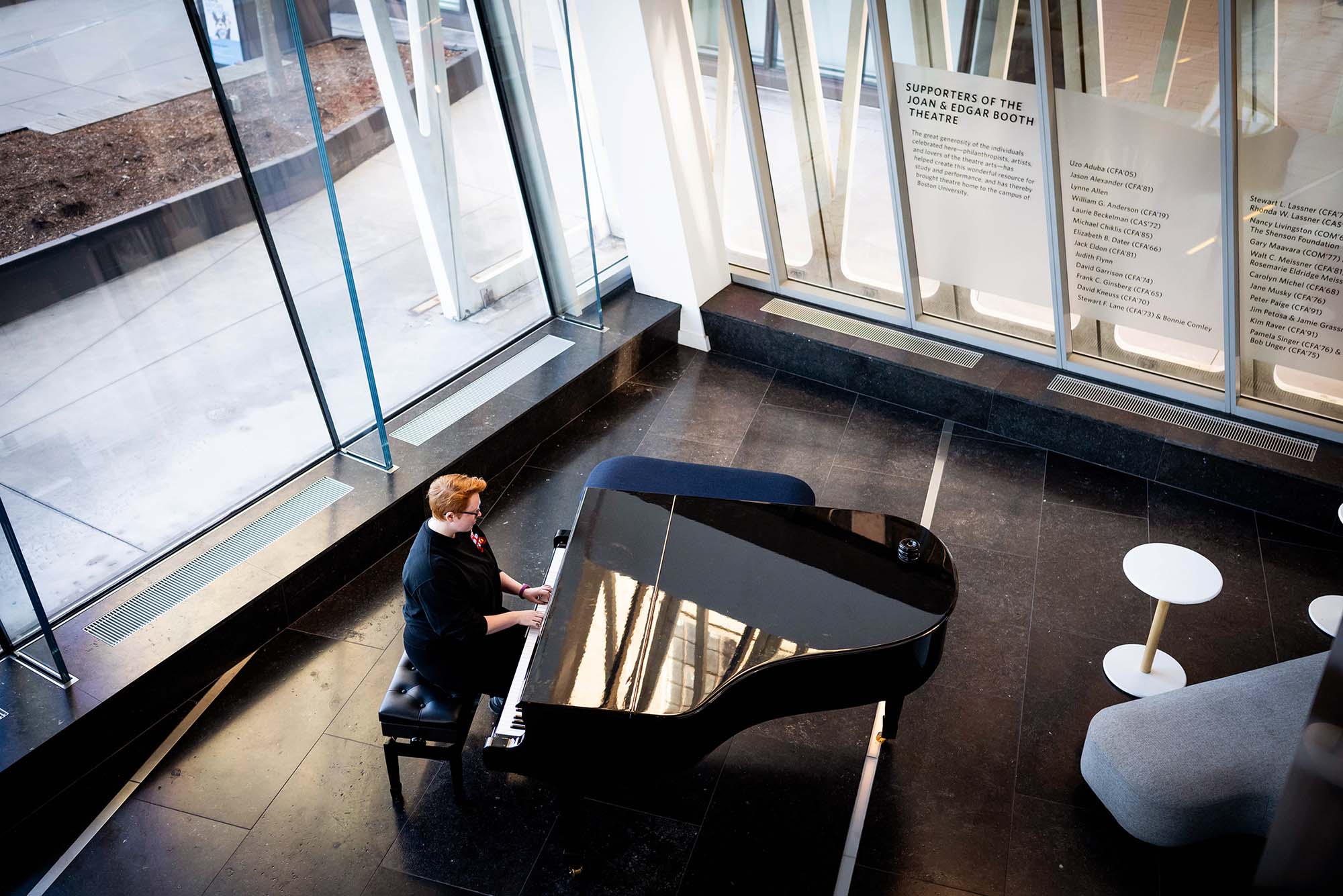 Photo: A student playing the piano inside of the Booth Theater