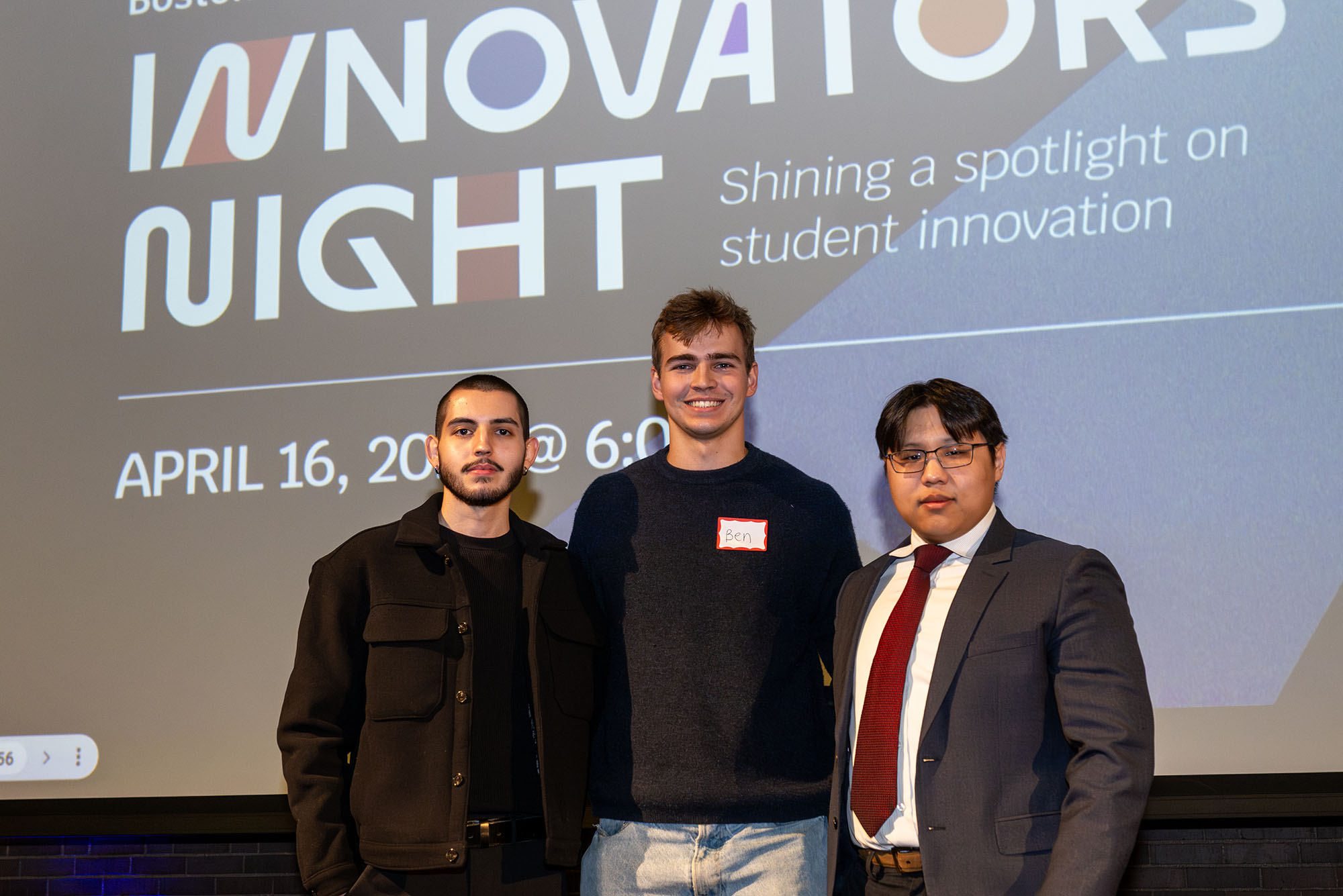 Photo: Three men posing in front of a projector screen that says "Innovators' Night"
