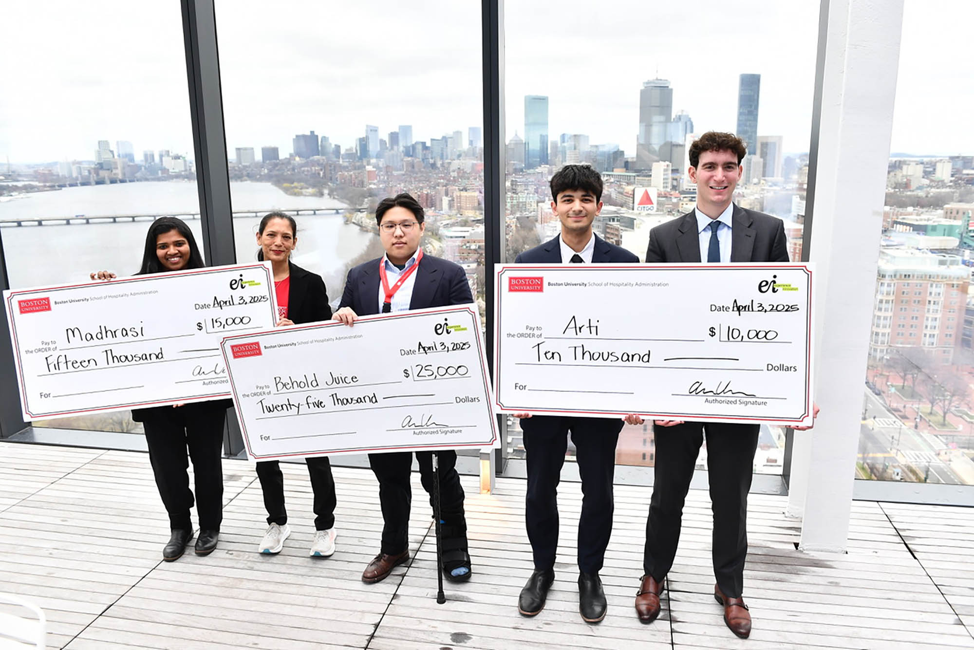 Photo: Five individuals holding three large cheques.