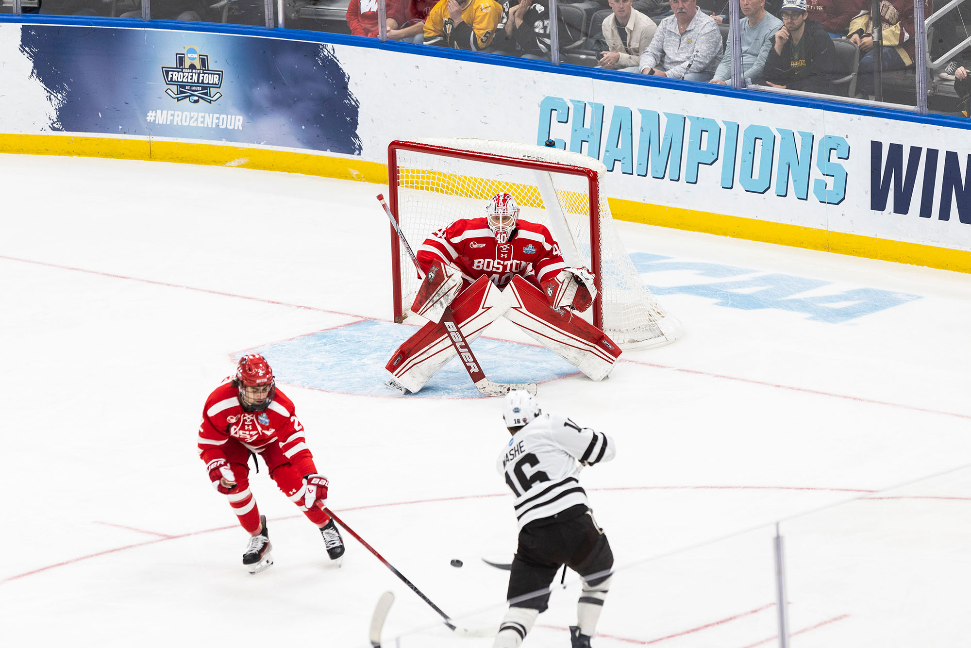 Photo: A hockey player from Western Michigan shooting to score at a Boston University goalie during a game