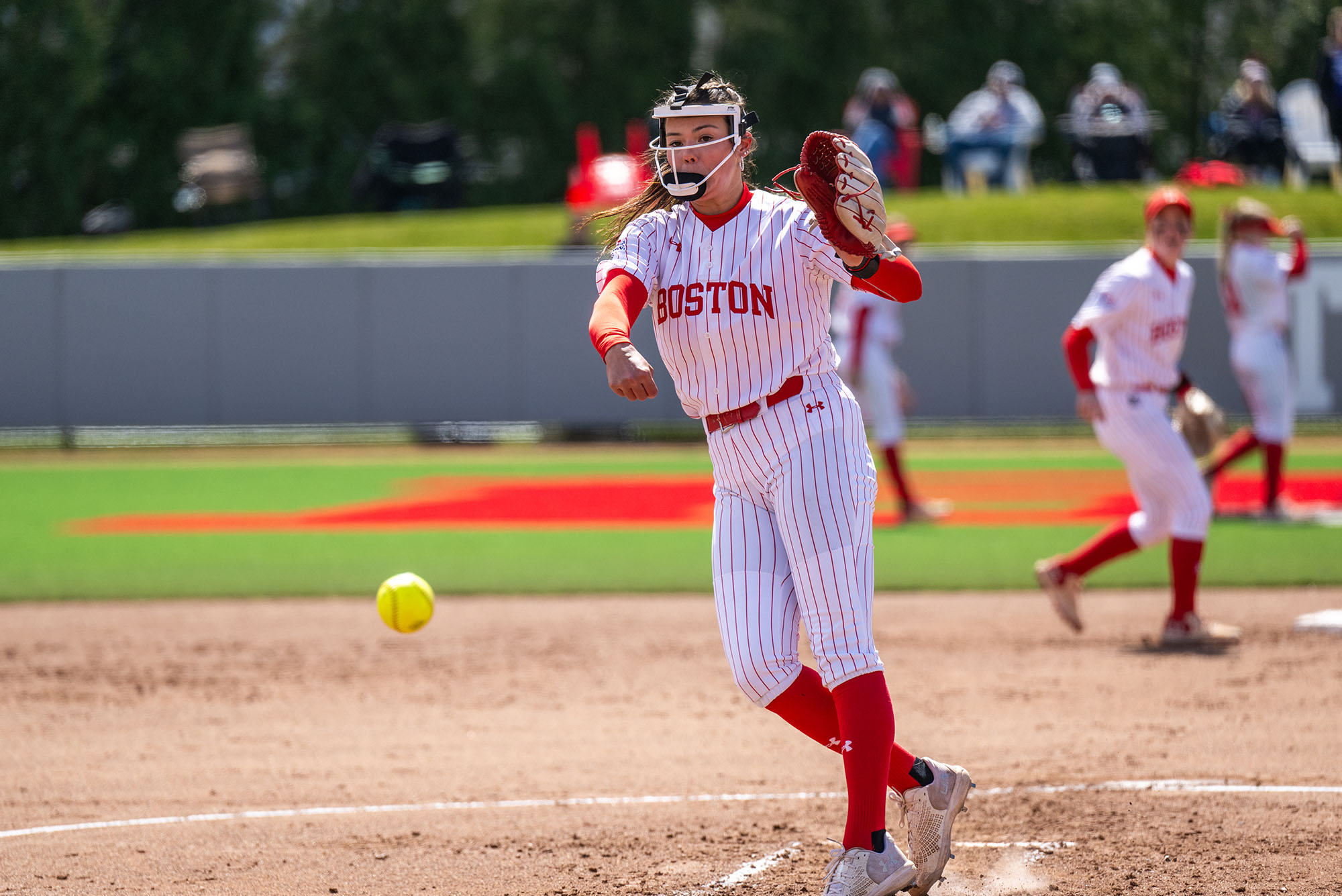 Photo: A female BU softball player pitching a ball during a game