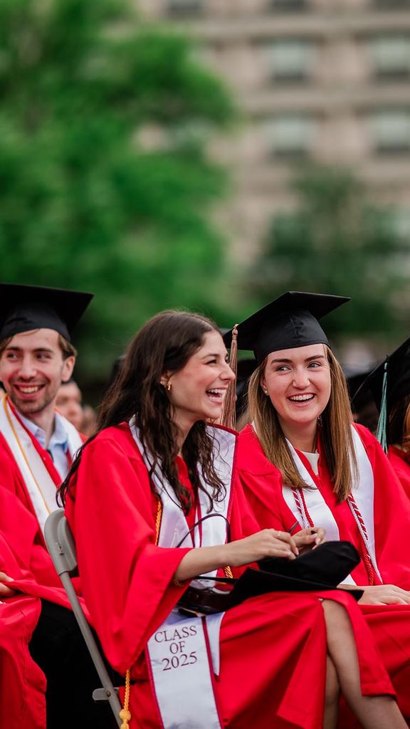 Photo: A group of graduates at Commencement 2025 with a white play button.