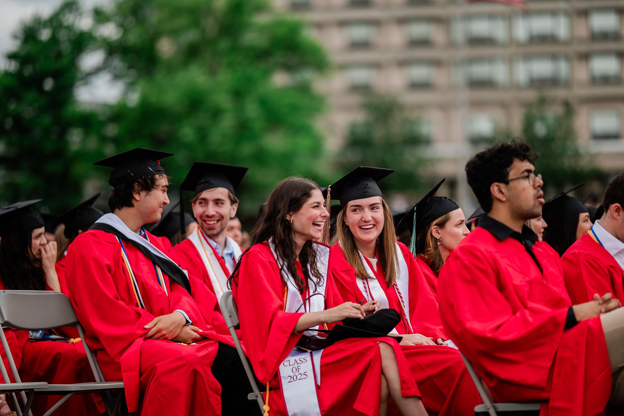 Photo: A group of graduates at Commencement 2025 with a white play button.