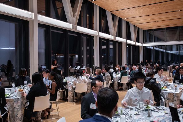Photo: A room filled with many tables and a speaker up front