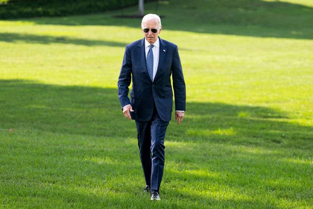 Photo: Former president Joe Biden walking across a green lawn
