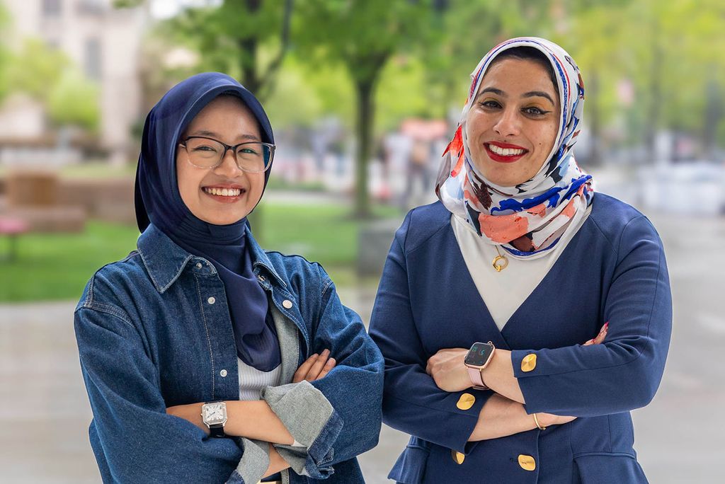 Photo: Two women posing with their arms crossed outside