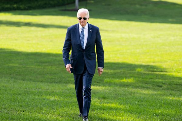 Photo: Former president Joe Biden walking across a green lawn