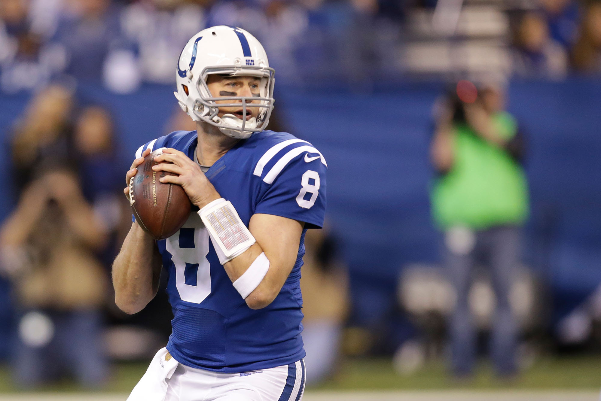 Photo: A football player in a blue uniform gearing up to throw the ball during a game