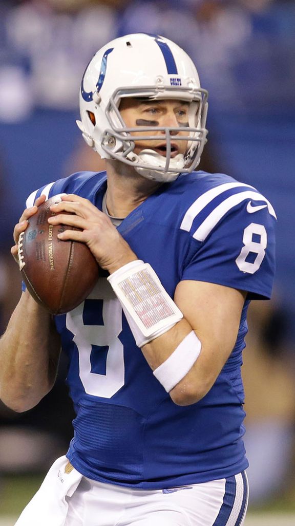 Photo: A football player in a blue uniform gearing up to throw the ball during a game