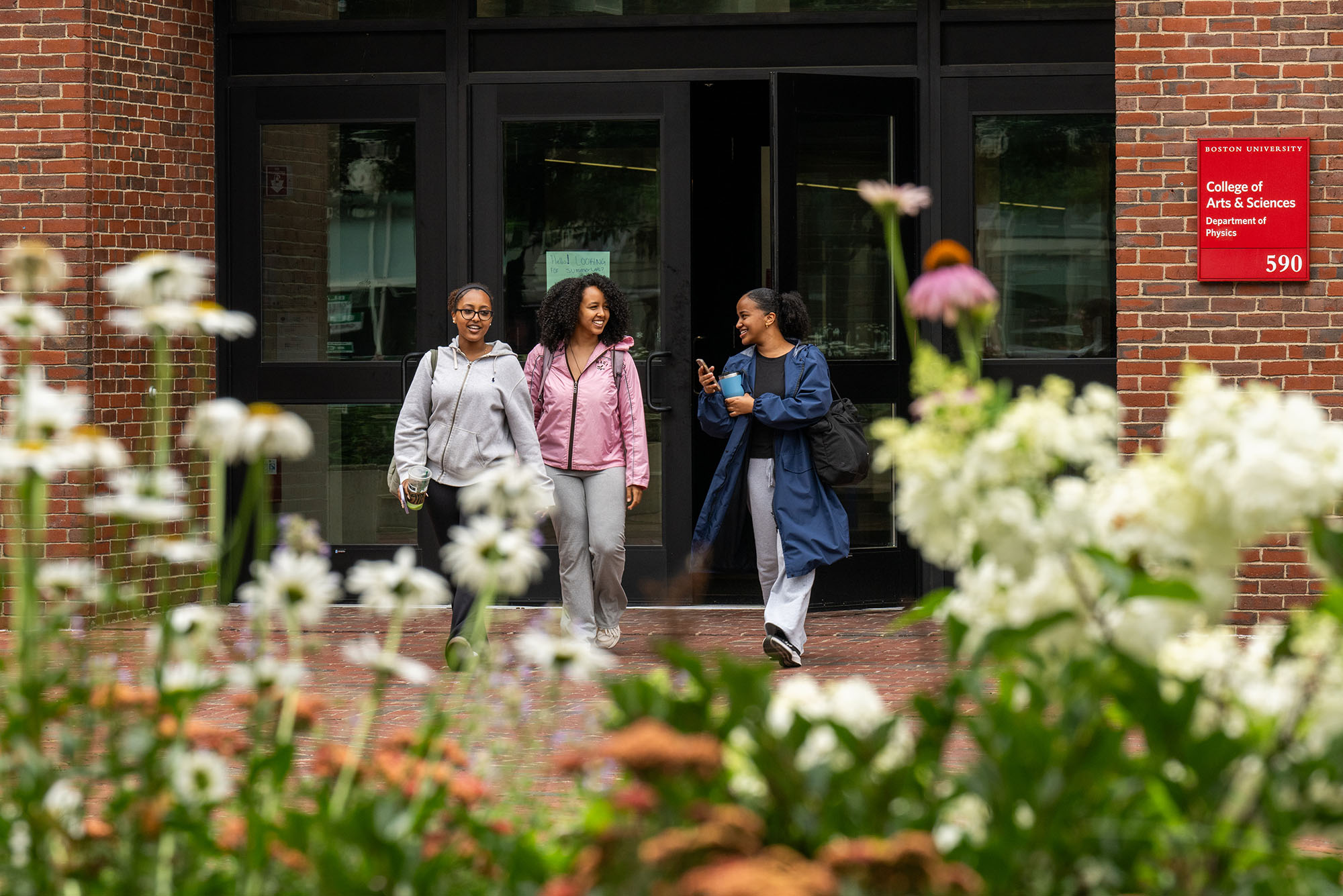 Photo: Three friends walking outside on BU's campus