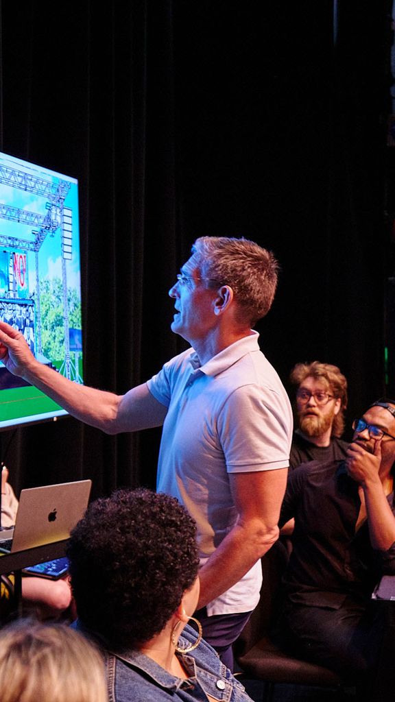 Photo: A man presenting a design in a theater company