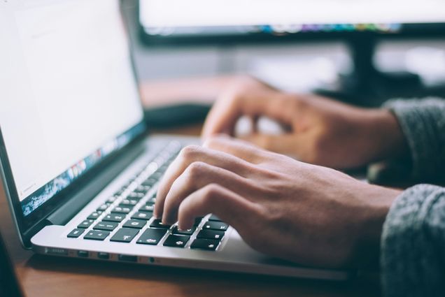 Photo: Person's hands typing on a laptop computer