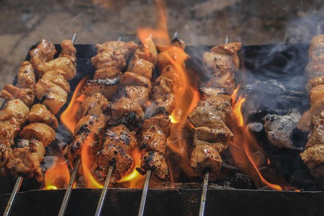 Photo: Skewers of meat cooking in a flame on a grill
