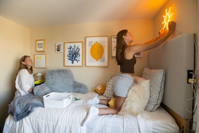 Photo: A mother and daughter decorating a Boston University dorm with a neon sign of a sun