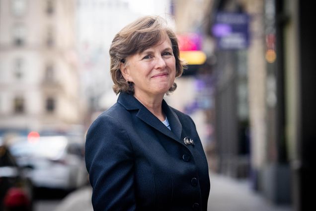 Photo: A white woman wearing a navy blazer poses for a portrait.