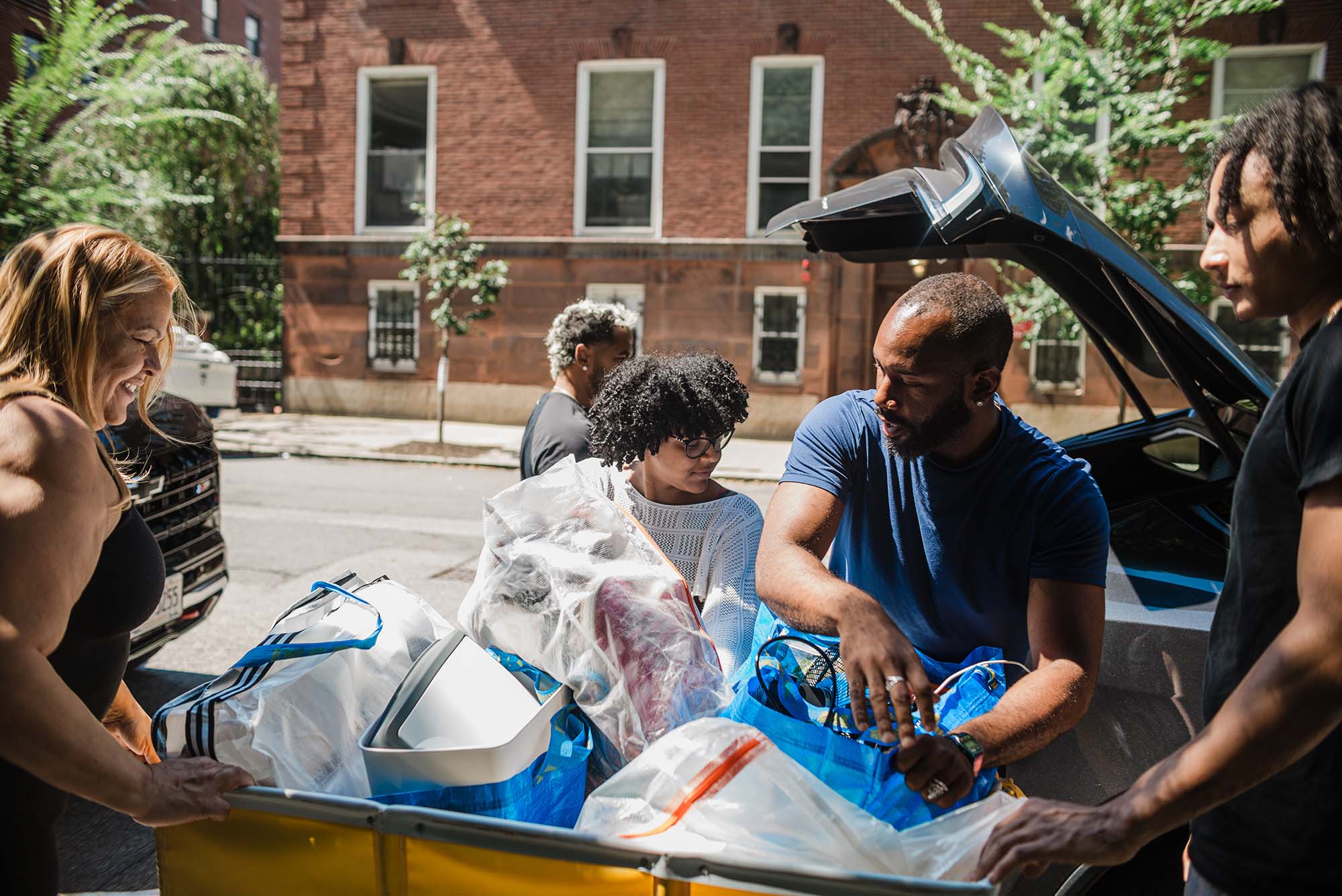 Photo: A family unloaidng a student's items into blue bins during Boston University's move-in
