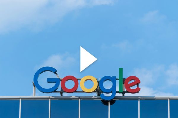 Photo: "Google" logo sign with colorful letters on top of a building. There is a video play button over the image