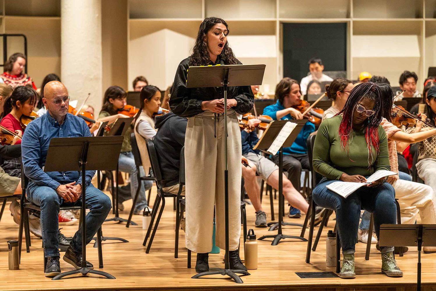 Photo: A woman at a podium sings an operatic.