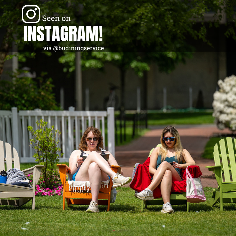 Photo: Two people sitting on Adirondack chairs at BU beach