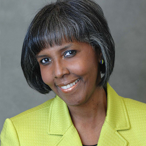 smiling headshot of Maureen Alphonse-Charles (CAS’85, Pardee’85) wearing a lime-green blazer.