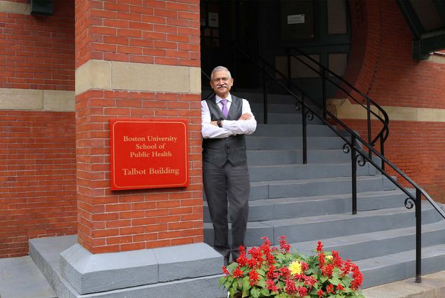 Photo: Dean Adnan Hyder posing next to Boston University's School of Public Health