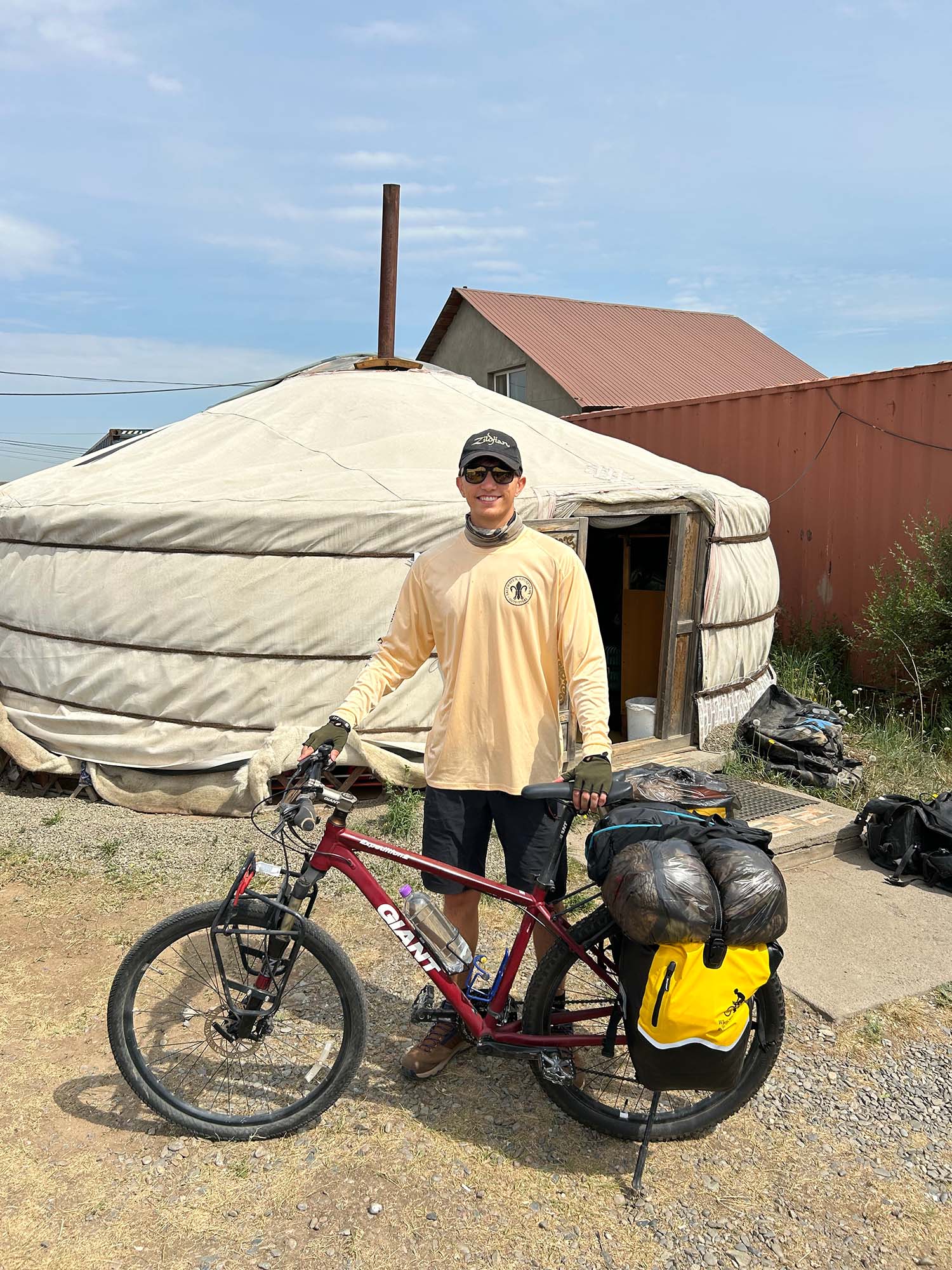 Photo: A BU student posing with his bicycle outside of a yurt