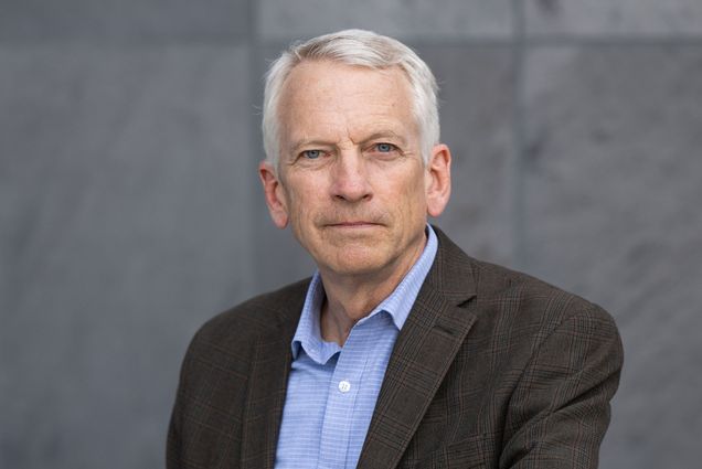 Photo: A man with short light hair poses for a formal portrait