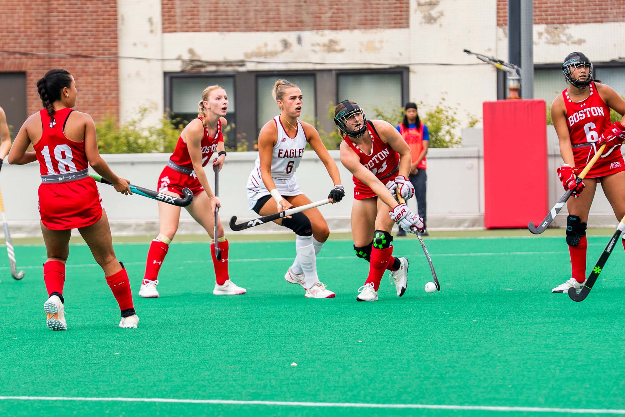 Photo: BU field hockey playing on the field in red uniforms