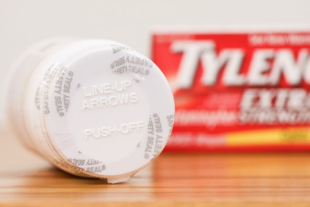 Photo: A bottle of Tylenol lying on a table with the box behind it