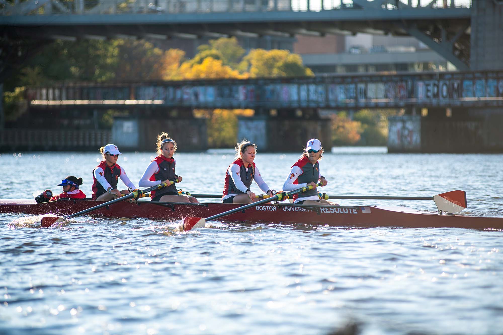 Photo: A group of BU crew members rowing on the Charles River.