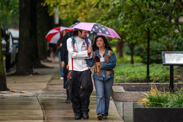 Photo: Two people walking under an umbrella on a rainy day