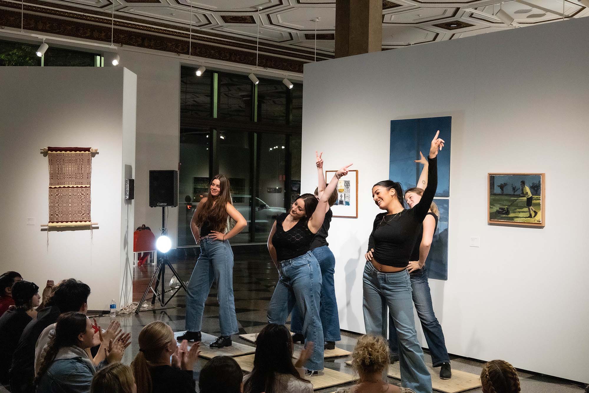 Photo: A group of individuals presenting a dance in a black top and jeans. They all hit a disco pointing pose.