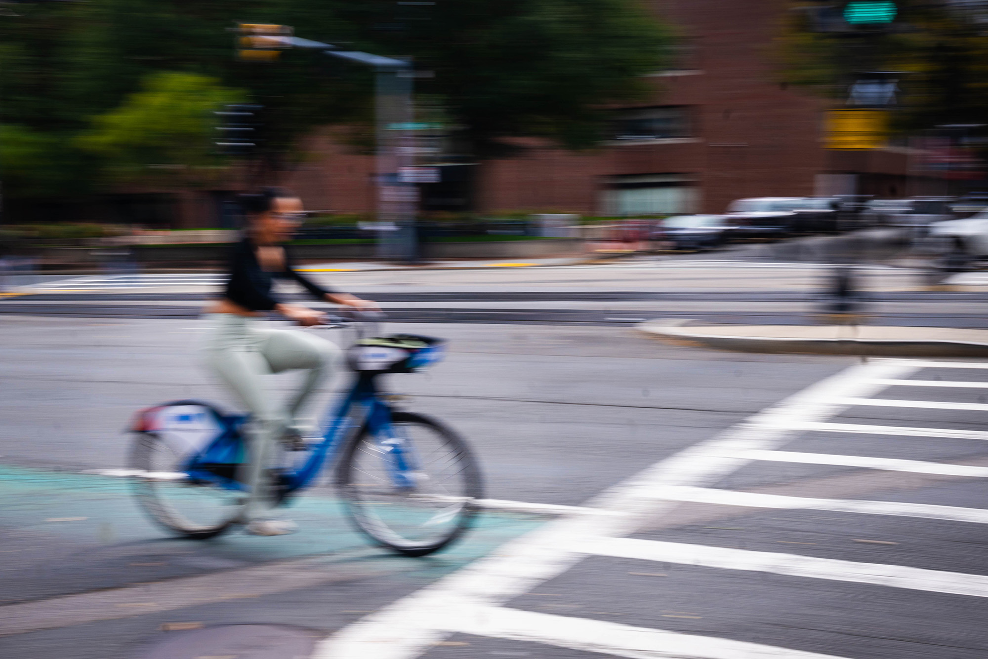 Photo: An artistically blurred photo of someone on a bicycle in a bike lane on Commonwealth Avenue in Boston