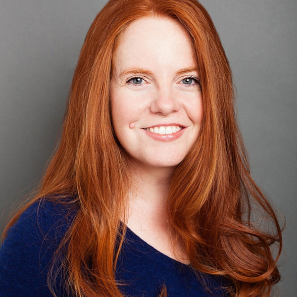 Photo: A young woman with bright auburn hair, wearing a navy shirt.