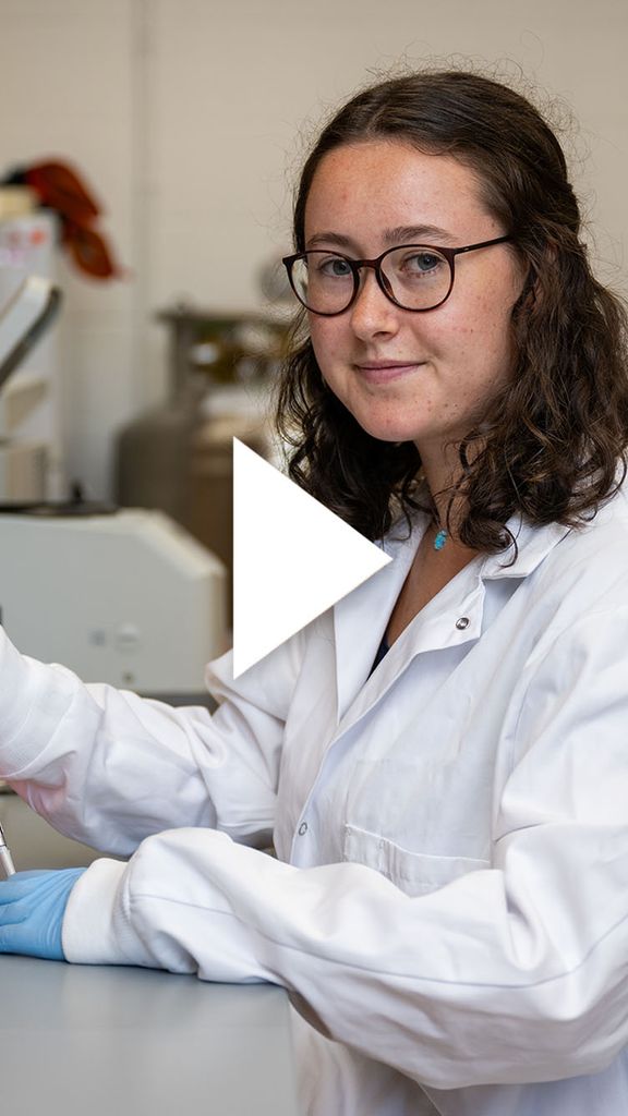 Photo: A researcher in a white lab coat pipes samples into dishes